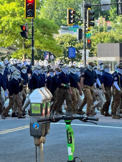 Hundreds of Patriot Front members walking through an intersection in DC, July 2026