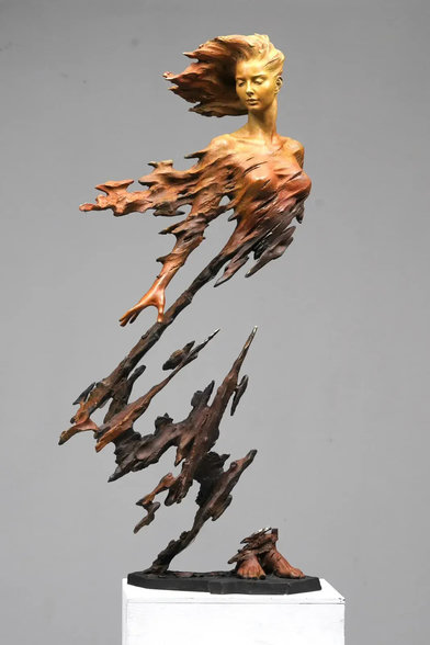 A realistic, serene woman whose lower torso and limbs dissolve into jagged, shard-like fragments anchored to the base with feet seemingly detached