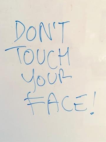 On the whiteboard in my kitchen, 'DON'T TOUCH YOUR FACE!', written in capitals in blue marker