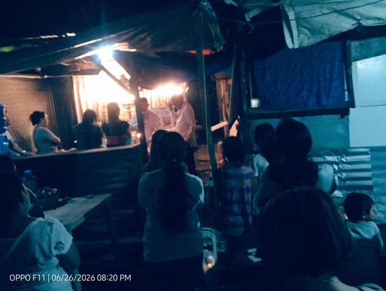 Traditional Funeral wake are held outdoors under tarps to accommodate many people in the Philippines specially in Provinces.
A photo taken at night shows a community gathering under a temporary tarp roof structure. 
A group of people sits on benches  On the right, other attendees sit on plastic chairs around a table. A timestamp at the bottom left reads "OPPO F11 | 06/26/2026 08:20 PM".