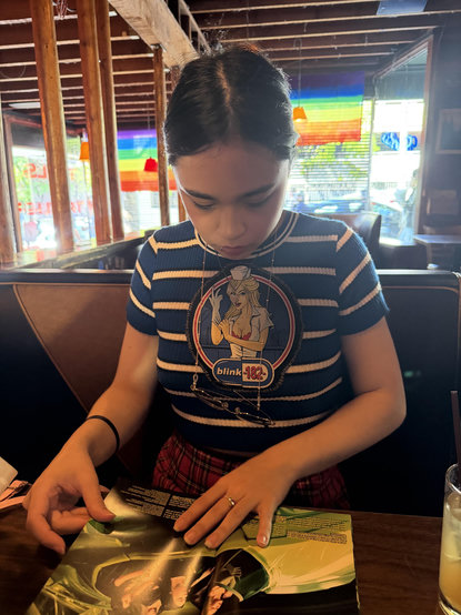 a woman looking at a poster in a bar