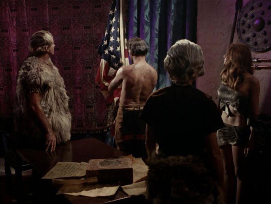Scene from Star Trek TOS episode "The Omega Glory" featuring a shirtless dude carrying an American flag because, sure, another planet had an America, too, why not.