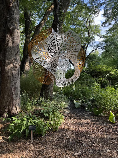 Dragonfly gyroid sculptors installed at Hortus Arboretum. It’s is white and gold aluminum 