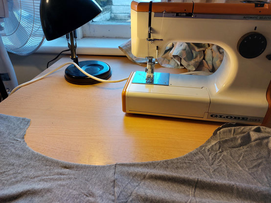 Part of a grey tshirt on sewing desk