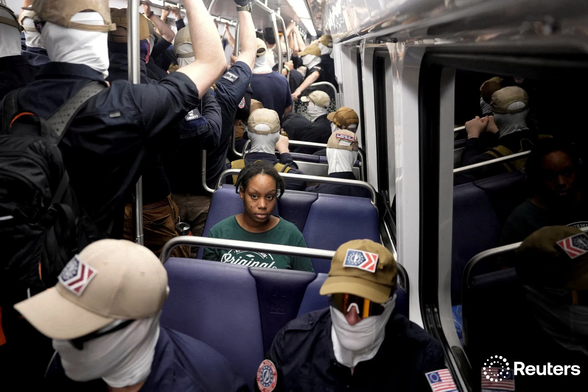 Members of the group Patriot Front ride the metro as a commuter looks on, during the 250th anniversary of U.S. independence in Washington, D.C., U.S., July 4, 2026. REUTERS/Cheney Orr