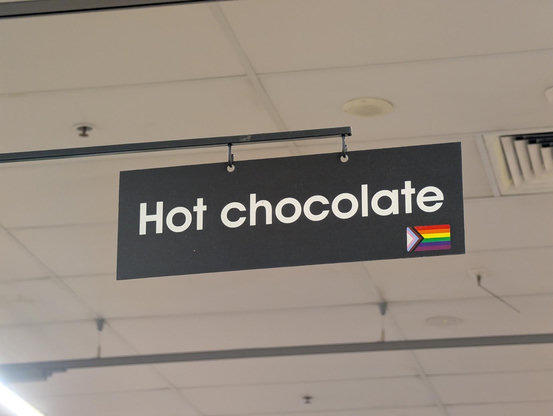 Hot chocolate sign with a gay pride flag sticker