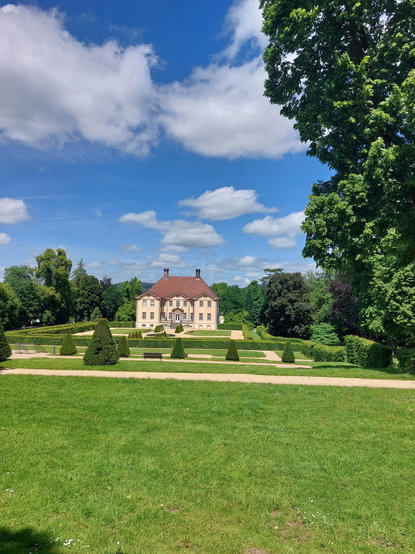 Ein schlossähnliches Gebäude in einem Barockgarten.