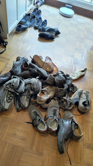Ein Haufen von etwa 20 Paaren von Halbschuhen (5 paar davon auf einem Haufen im Hintergrund), in der Regel in dunklen Farben, sowie ein paar Schlittschuhe. Die meisten sehen nicht mehr schön aus.