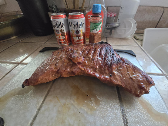 Tritip roast on a glass board. Special Modelo cans on background. Shot on wide angle lens for "effect", so things seem exaggerated. 