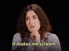 a woman in a striped shirt says it makes me scream in front of a microphone