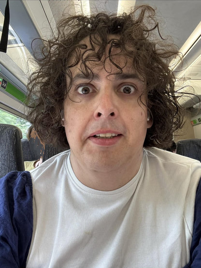 Looking mildly dishevelled on a train seat. Having just run for the train