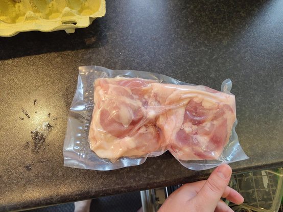 a vacuum sealed freshly thawed package of chicken thigh