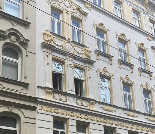 Farbfoto: Stuckfassade mit Fenstern, teilweise mit Rettungsdecke abgedeckt