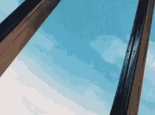 looking through a window at a blue sky with white clouds