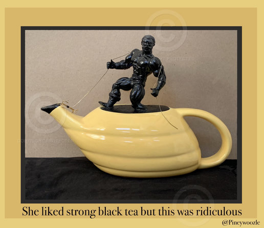 Art deco teapot, where the lost lid has been replaced with an action figure painted black and climbing out of a flat black surface at the top of the teapot. He’s holding a chain with a grappling hook on the end that’s attached to the spout of the teapot to help him climb out.. under the photograph on the mat, which is the same colo yellowr as teapot  are the words “She liked strong black tea, but this was ridiculous”  @Pineywoozle 