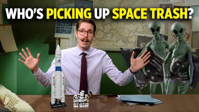 YouTube-style thumbnail featuring a man in a shirt and tie sitting at a desk with his arms raised. Large text at the top reads: “WHO’S PICKING UP SPACE TRASH?” in white and yellow letters. A model rocket and small toy figures are placed on the desk. In the background are maps, space-related images and notes pinned to a wall. Two alien figures holding black trash bags appear on the right side of the image, illustrating the topic of cleaning up space debris.