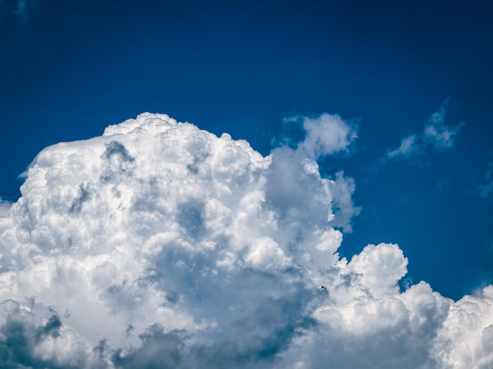 Large white fluffy clouds in a dark blue sky