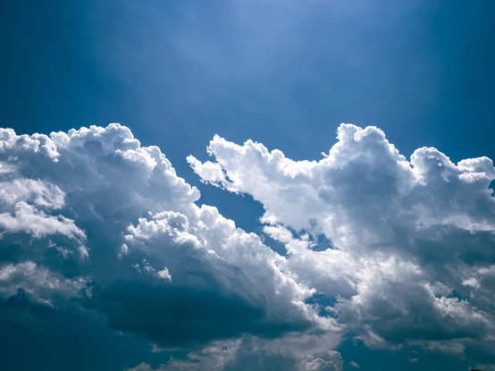 Large white fluffy clouds in a dark blue sky
