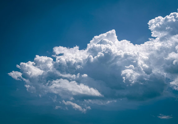 Large white fluffy clouds in a dark blue sky