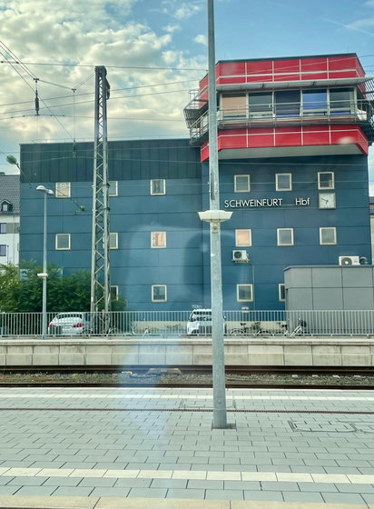 Bahnsteig, dahinter ein Haus, welches mit Schweinfurt Hbf beschriftet ist