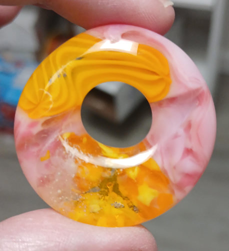 ok all these except the last one are small circles with holes, about an inch and a half across, with a slightly thinner top part and more weight on the bottom. this one is layers of yellows and speckled pinks
