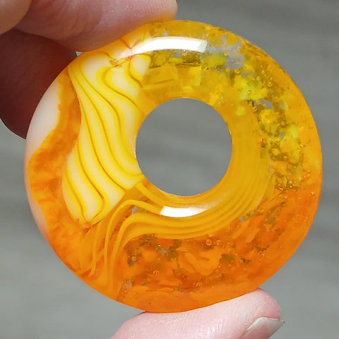 yellow and orange pendant with mixes of speckles and twists