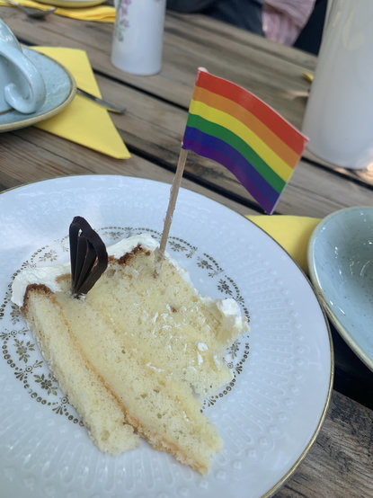 En bit tårta som någon stuckit en Regnbågsflagga i
