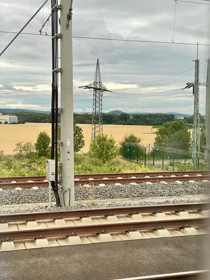 Blick aus dem Zugfenster, Gleise, Masten, Feld, Wald und hinten sieht man die Veste Wachsenburg