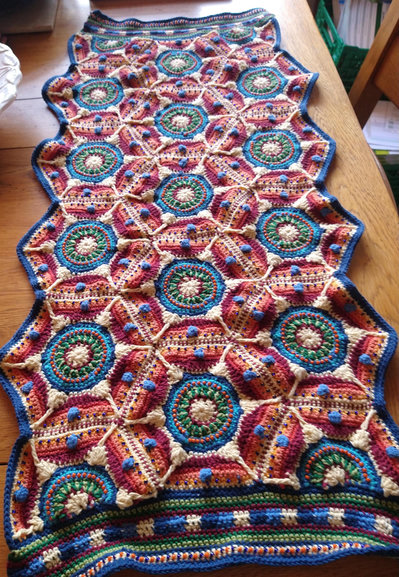 Multi coloured Crochet piece laid on a dining table