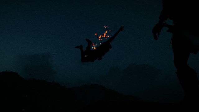 Bild från Assassins Creed Odyssey. 
Siluetter. Man ser lite ben och hand från Kassandra som ser en brinnande person falla ned.