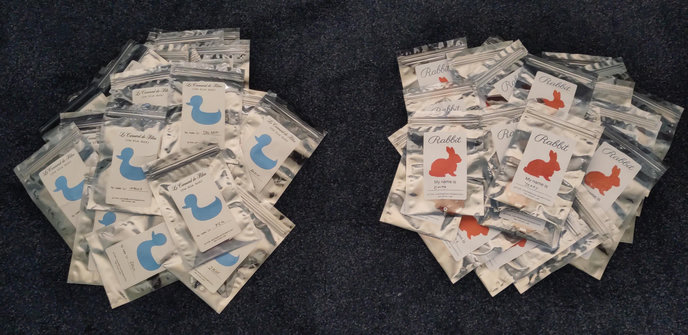 "Le Carnard de Bleu" and "Rabbit" hexpansions in packaging, in two piles on the floor.