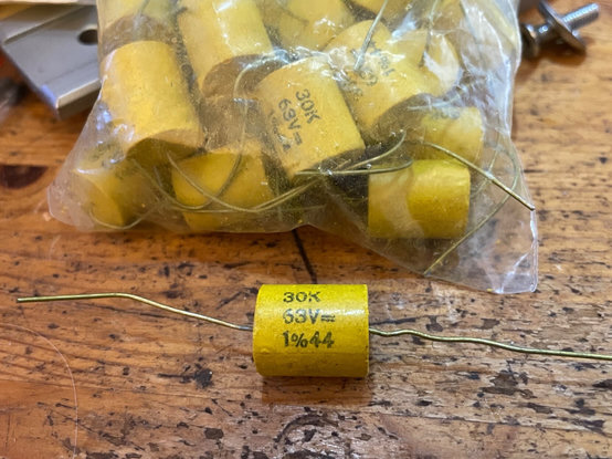 A yellow axial leaded through hole capacitor about 12mm in diameter and 15mm long