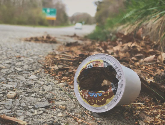 Photo of a discarded coffee pod lying by the side of a road