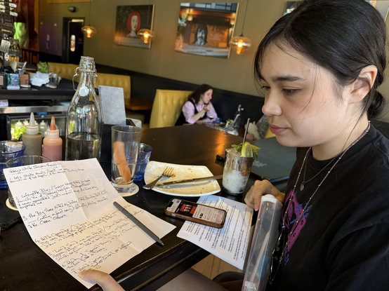 a woman pointing out something about the text on a piece of paper
