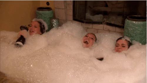 Clip of three people in a jacuzzi, barely visible because they're covered in thick foam.