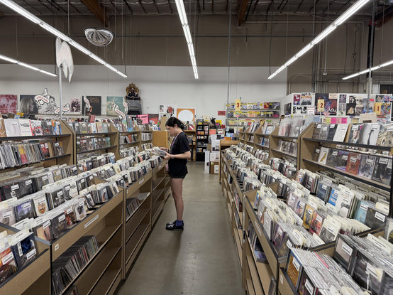 a woman in a long isle of CDs