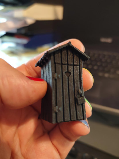 Small outhouse in black filament. It's got a nice slanted roof and a small sign on the door knob and a little heart in the door as it should.